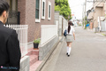 Student walking along street in uniform long hair in ponytail.jpg