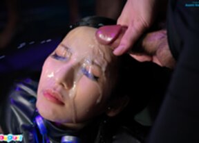 Asami Kondo seated surrounded by men receiving bukkake cumshots