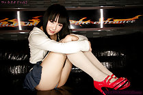Mizushima Ai seated with knees drawn up wearing short skirt in high heels