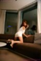 Sakuraba aya kneeling on sofa in white dress high heels