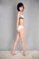 Looking back wearing bra and panties in high heels