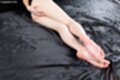 Lying on her side nude hand on her ass bare feet pressed together