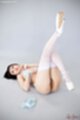 On her back leg raised wearing stockings white high heels