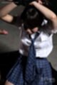 Arms raised above her head wrists tied wearing uniform